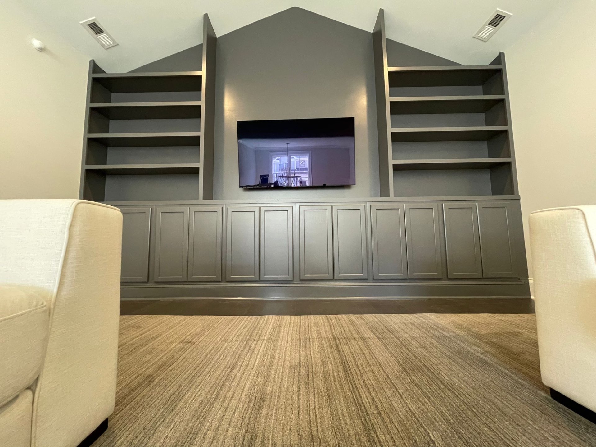 Floor-to-ceiling built-in bookcases and cabinets painted a uniform gray