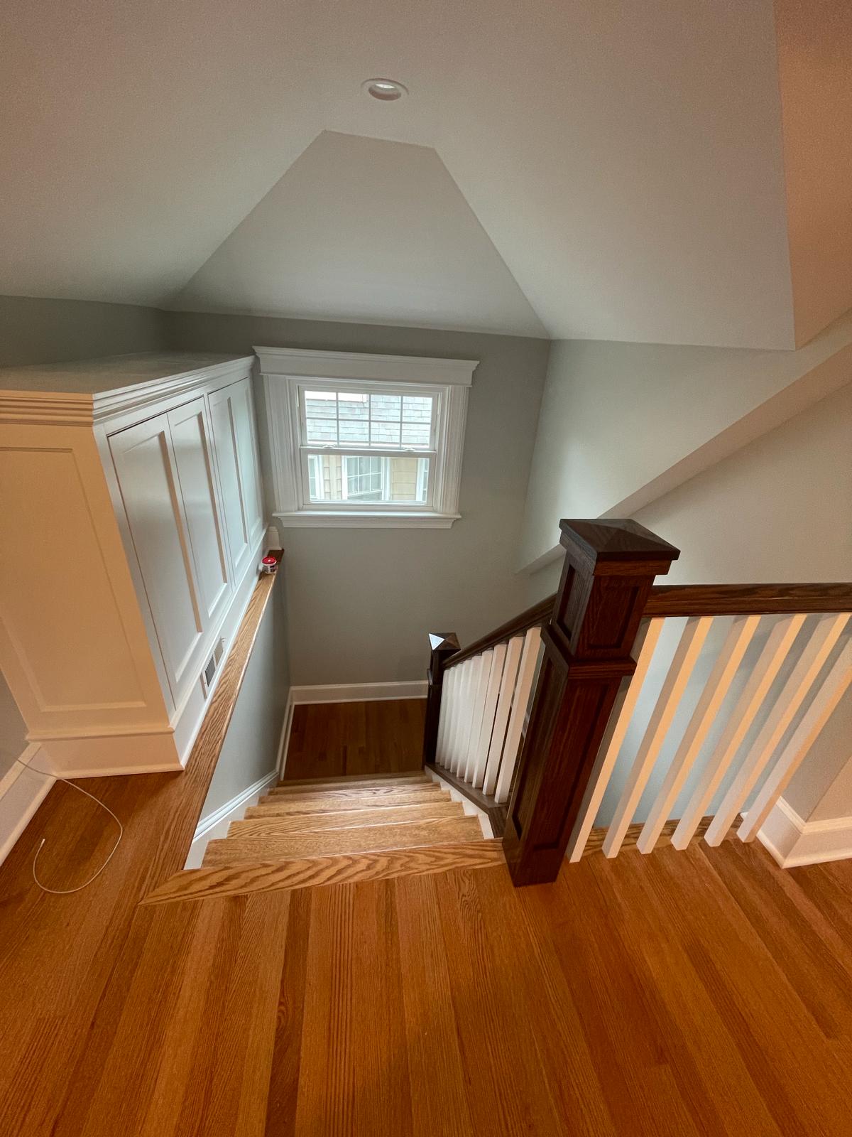 Freshly painted stairwell with white paneling, trim and soft gray walls